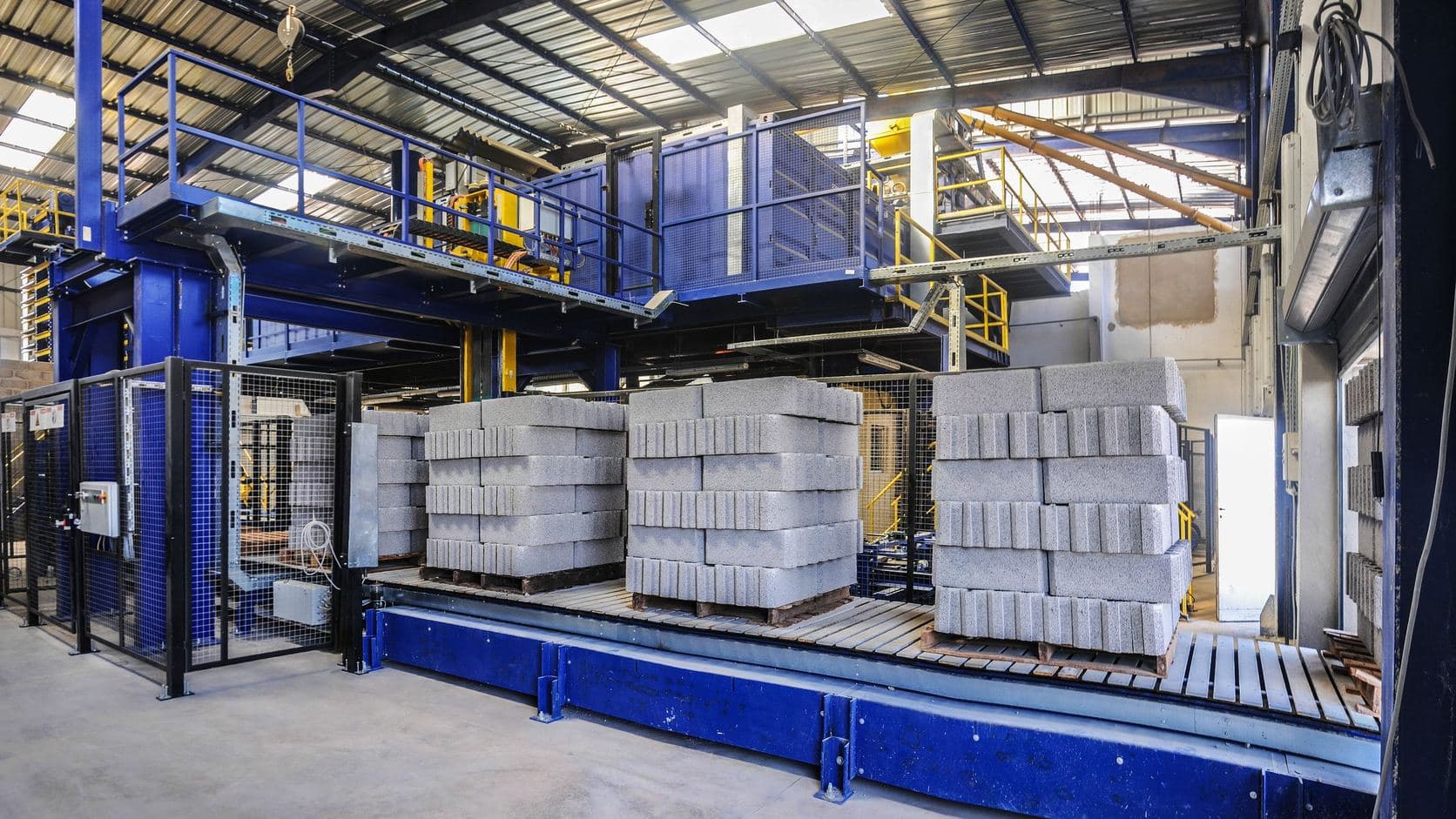 Concrete blocks stacked on pallets on the conveyor of a block plant