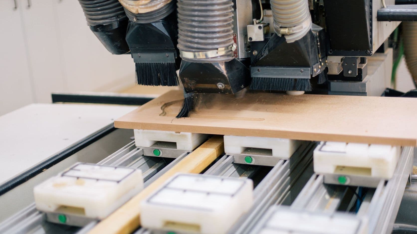 A CNC router cutting a wooden panel in a woodworking shop